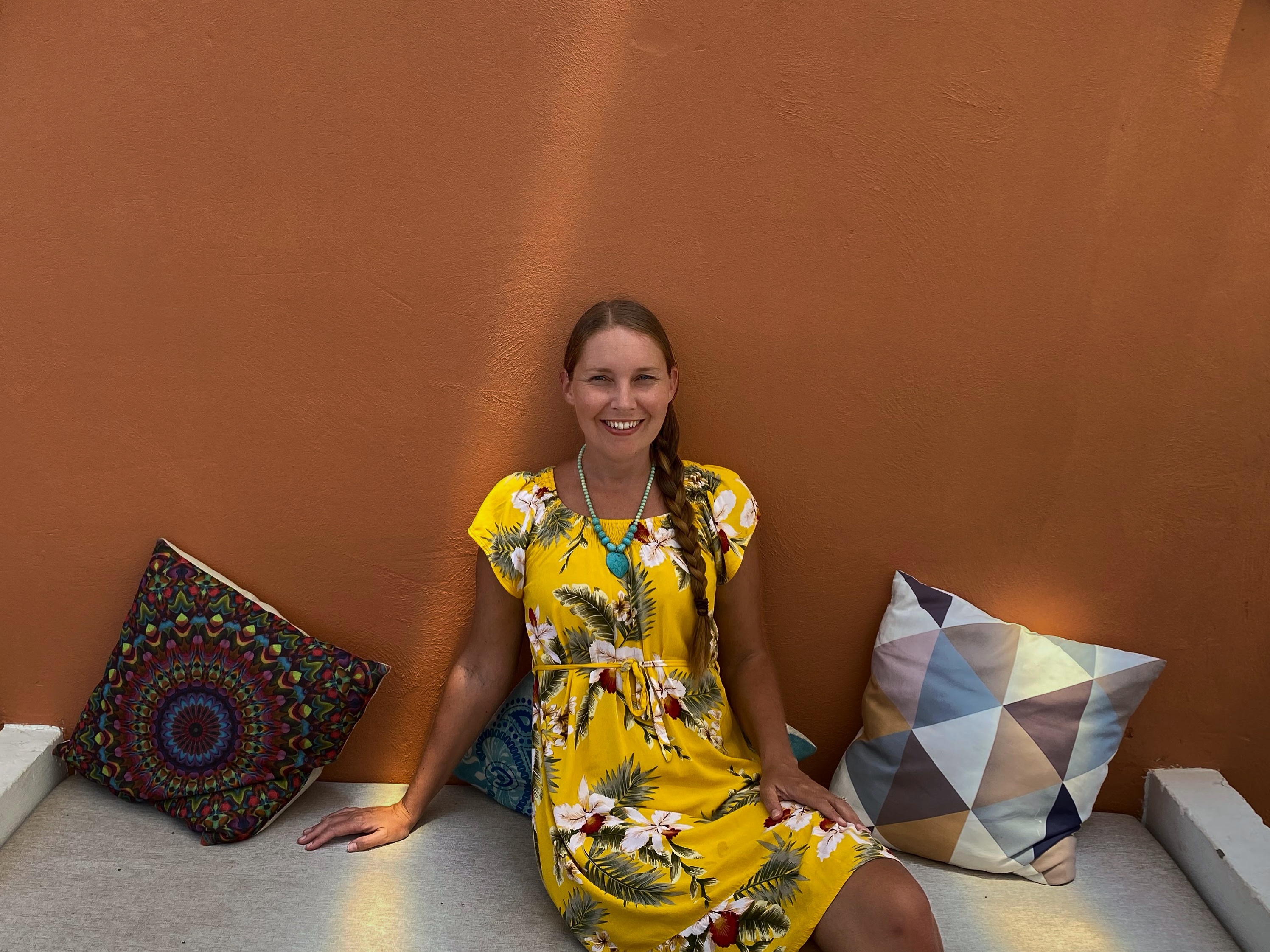 Melissa Wiringi seated against a terracotta wall